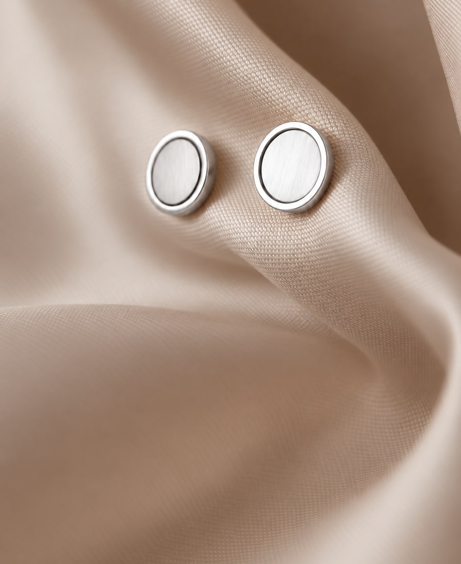 Ellipse — Oval diamonds held in smooth bezels on a brushed gold post.