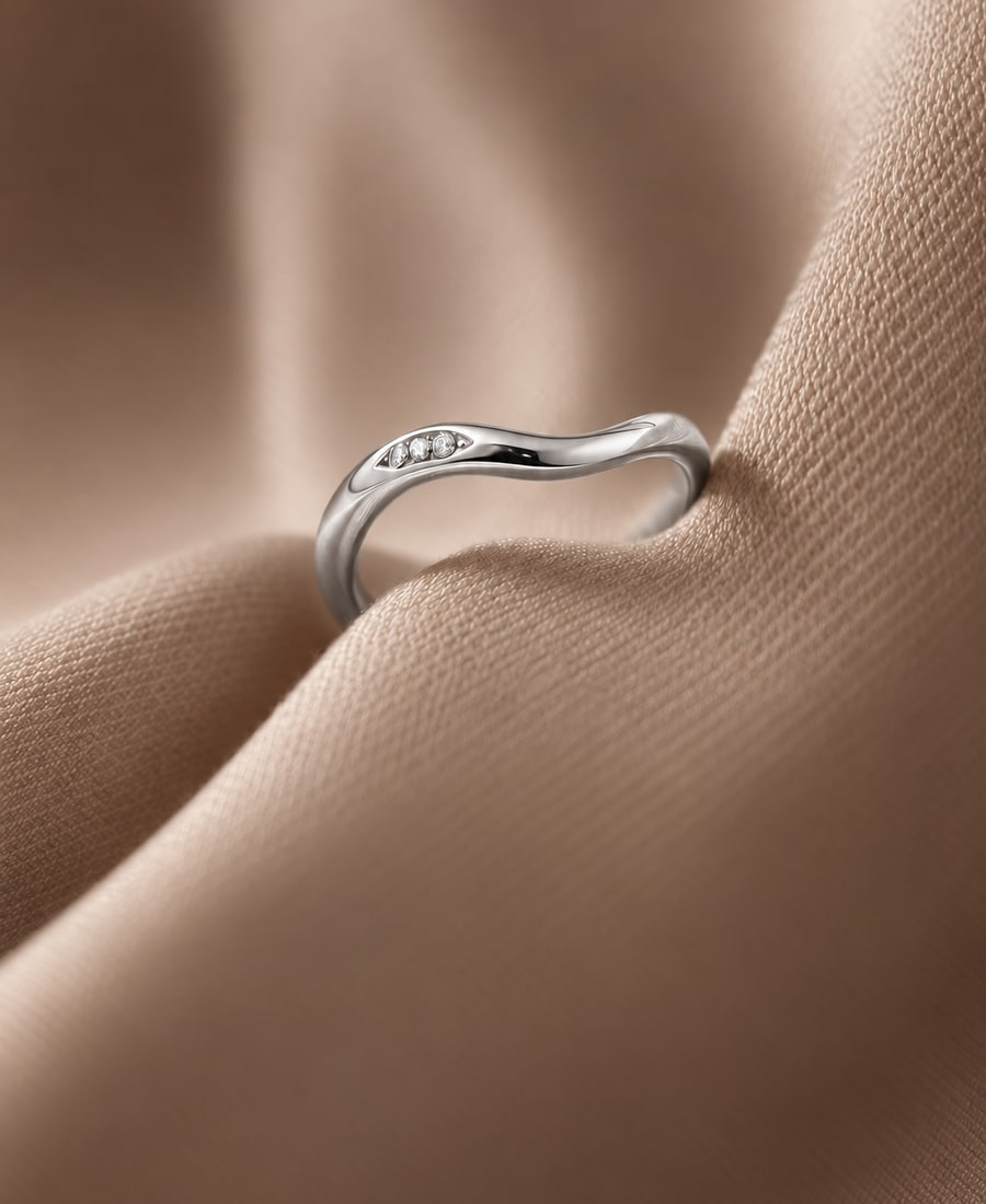 Marée Ring — A wave-form band with channel-set round diamonds following the curve.